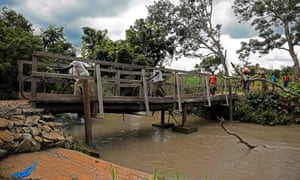 Refugees from South Sudan cross a bridge over the Kaya river in Koboko district in 2017