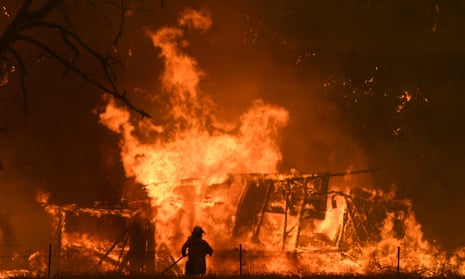 A firefighter tackles a wall of flames