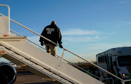 An Ice officer watches as people are deported from the US in 2018.