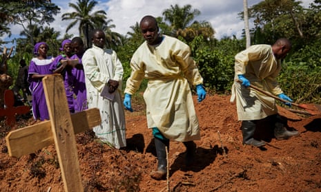 Health workers take part in the funeral of a woman infected with Ebola in her home village of Mutwanga, in North Kivu province, Democratic Republic of the Congo.