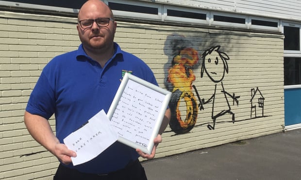 Site manager Jason Brady holding a letter left by Banksy at Bridge Farm primary in Bristol