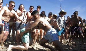 Two men wrestle each other as spring break revelers look on on March 17 in Pompano Beach, Florida. As a response to the coronavirus pandemic, the governor ordered all bars be shut down for 30 days.
