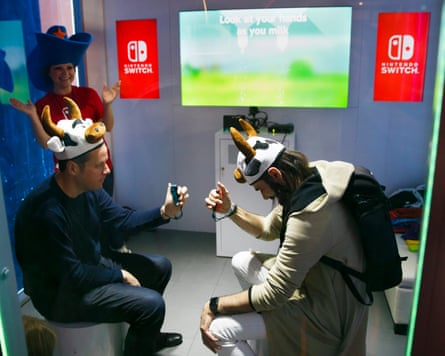 Two people in cow hats compete in a game that simulates milking a cow on the new Nintendo Switch game console during a media preview event in New York, New York, USA, 13 January 2017.