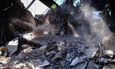 Rescuers work at a site of a shopping mall hit by a Russian missile strike.