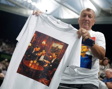 A Novak Djokovic fan shows off a T-shirt depicting Djokovic smoking cigars with Federer and Nadal.