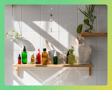 A wooden shelf displays various bottles, plants, and diffusers against white tiled wall with geometric shadows