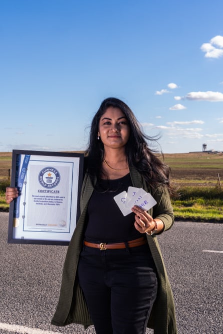 Guinness World Record holder Sruthy Saseendran holds her framed Guinness World Record certificate and some of the palm cards she used while practicing.