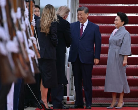 Xi Jinping shakes hands with Donald Trump as their wives Melania Trump and Peng Liyuan look on.