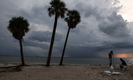 Los residentes llenan sacos de arena en la playa Ben T Davis en Tampa, Florida, mientras se acerca el huracán Ian