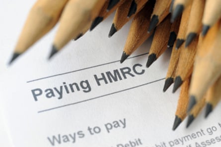 A bunch of brown pencils hovers over an HMRC document