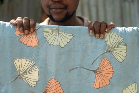 An LGBTQ+ refugee from Uganda hangs a blanket on a clothesline