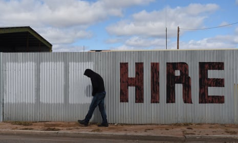 A man walks past a hand painted hire sign