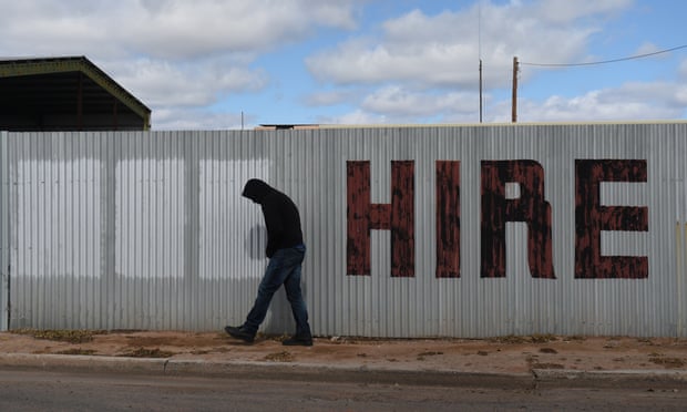 A man walks past a hand painted hire sign
