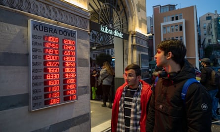 two men peruse a currency exchange board in Turkey