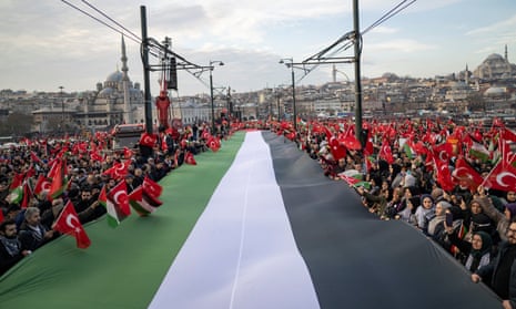 Holding a huge Palestinian flag, thousands demonstrate to show solidarity with the Palestinian people on the Galata Bridge in Istanbul.