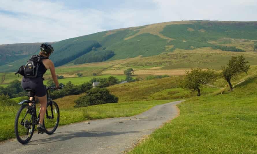 A cyclist rides past Fair Oak Fell in the Forest of Bowland.