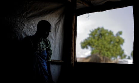 A South Sudanese refugee who was raped for several days by soldiers stands by a window at a women’s centre run by the International Rescue Committee, in Bidi Bidi, Uganda
