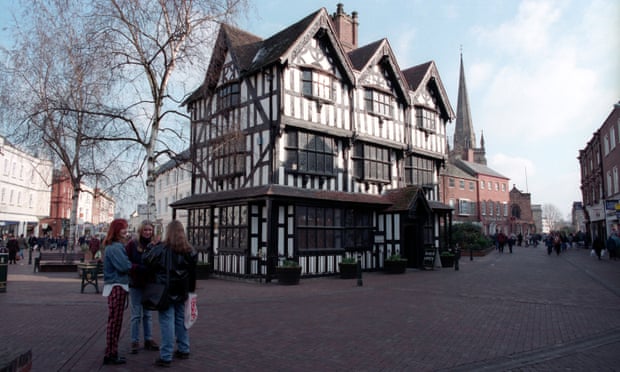 Group of young women next to a timber framed house in Hereford town centre
