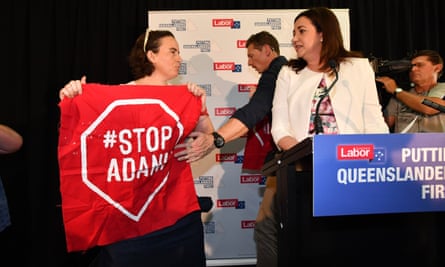 Anti-Adani coalmine protestors invade the stage as Queensland premier Annastacia Palaszczuk (right) delivers a speech.
