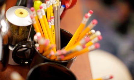 A bunch of pencils in a mug on a teachers desk