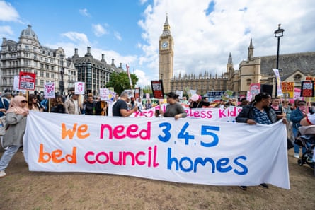 People at a protest holding a large banner reading 'we need 3, 4, 6 bed council homes' with the Houses of Parliament in the background