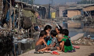 Children play outside their home, next to a polluted canal which empties out into the Buriganga river.