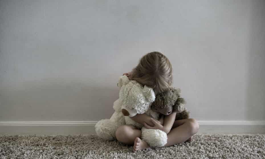 A little girl hugging a teddy
