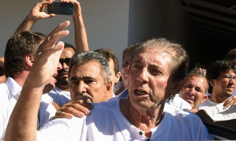 João Teixeira de Faria is escorted by supporters upon arriving at the the Dom Inácio de Loyola house in Abadiânia.
