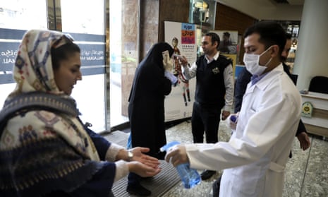 People have their temperature checked and their hands disinfected at a shopping centre in Tehran, Iran.