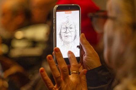 A woman looks at a portrait on a smartphone