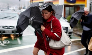 Pedestrians shield themselves from the wind and rain during a storm in Wellington.