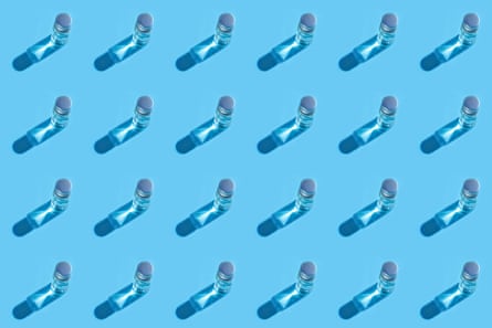 Small vials of vaccines arranged in a grid, viewed from above on a pastel blue background