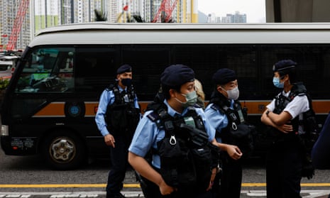 Police stand guard as a prison vehicle arrives at the West Kowloon magistrates court building.
