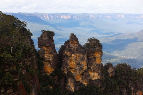 A spectacular sandstone rock formation with a blue-green valley below
