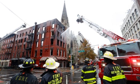 New York City firefighters work to extinguish a fire which erupted next to the Middle Collegiate Church.