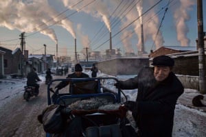 Daily Life, first prize, singles - Kevin Frayer - Chinese men pull a tricycle in a neighborhood next to a coal-fired power plant in Shanxi, China