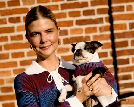 A woman holds a small dog