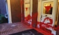 Red paint is splashed across the front of a house.