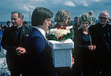 ‘We can’t go on like this’ … a father carries a coffin at the funeral of three of his children in August 1976.