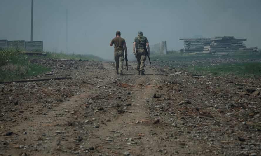 Ukrainian service members walk on the road near the town of Soledar in the Donetsk region, Ukraine, 8 June, as Russia’s attack on Ukraine continues.