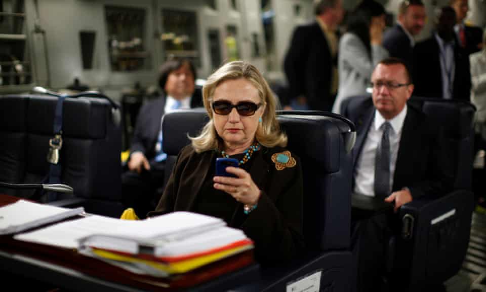 As secretary of state, Hillary Clinton, checks her PDA upon departure in a military C-17 plane from Malta bound for Tripoli, on 18 October 2011.