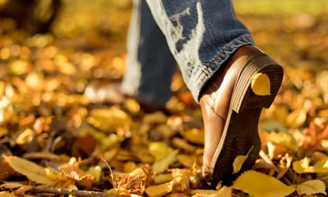 Woman's boots in fallen autumn leaves