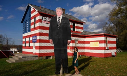 Leslie Rossi poses with a giant cutout of former US President Donald Trump in front of the “Trump House”, which she owns and created in 2016, in Youngstown, Pennsylvania