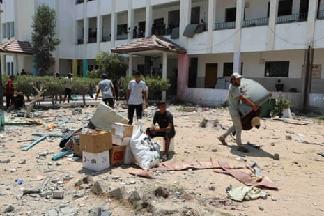 Palestinians leave a school sheltering displaced people after an Israeli strike, in Deir Al-Balah in the central Gaza Strip on Saturday.