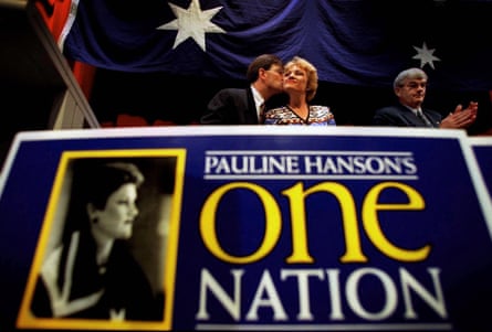 Oldfield kisses Hanson at a podium displaying a huge party banner