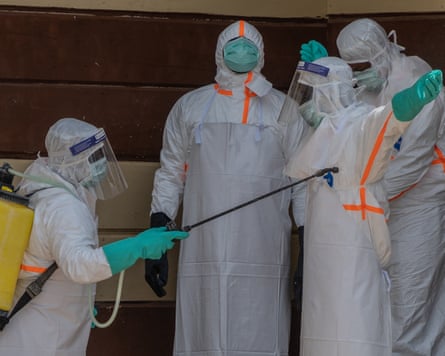 Healthcare workers disinfect themselves after preparing the body of an Ebola victim at Citadelle clinic in Bunia, Congo