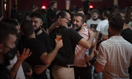 Person at the event embracing friend without his mask on.