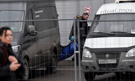 A law enforcement officer carries out the body of a victim of the gun attack, to load into a hearse at the Crocus City Hall in Krasnogorsk, outside Moscow, on March 23, 2024.