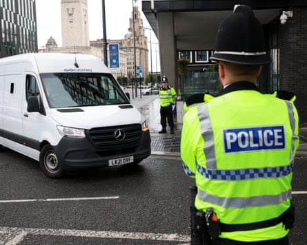 White van with police officer looking on