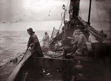 The crew of a Yarmouth herring boat pull in their catch on a stormy North Sea in the 1930s.